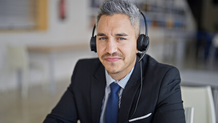 Young hispanic man business worker using laptop and headphones at office