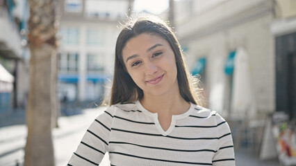 Young beautiful hispanic woman smiling confident standing at street