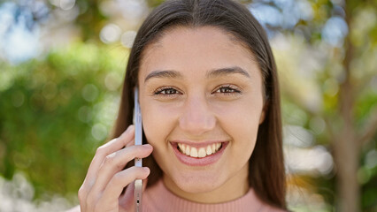 Young beautiful hispanic woman smiling confident talking on smartphone at park