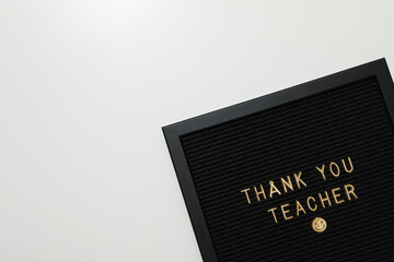 The inscription on the dark board: "Thank you, teacher!"