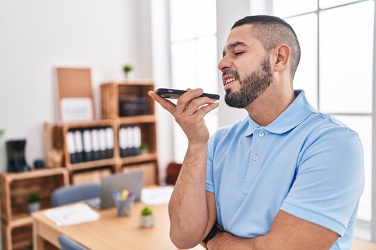 Young latin man business worker smiling confident talking on smartphone at office