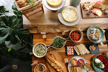 Uma visão deslumbrante de cima, revelando uma mesa repleta de comidas maravilhosas. Cada prato é uma obra-prima, cuidadosamente preparada e disposta com todo o capricho. 