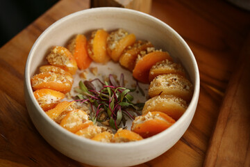 Uma verdadeira tentação: damascos recheados de xerém de nozes, cuidadosamente dispostos em uma travessa de cerâmica artesanal. Um verdadeiro deleite para os amantes de sabores intensos e texturas.