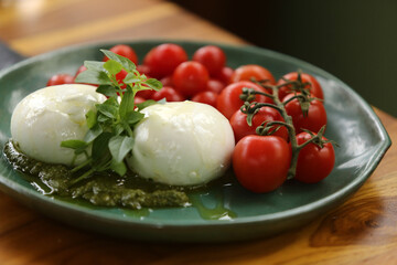 Uma mesa de comidas irresistível em um evento especial. As lindas burratas com tomates em rama e pesto de manjericão são os destaques, trazendo frescor e sabor à celebração.