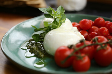 Uma mesa de comidas irresistível em um evento especial. As lindas burratas com tomates em rama e pesto de manjericão são os destaques, trazendo frescor e sabor à celebração.