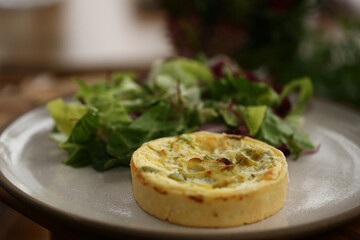 Uma combinação perfeita: quiche deliciosa acompanhada por uma refrescante salada de folhas verdes, em um evento repleto de capricho.