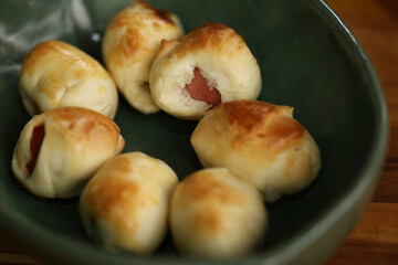 Deliciosos salgadinhos recheados de salsichas em um evento cheio de comidas gostosas. Uma opção irresistível para petiscar e aproveitar momentos especiais.