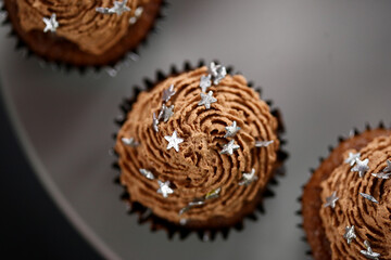 Cupcakes de chocolate decorados com estrelas prateadas, uma doce e encantadora adição à mesa de doces da festa de aniversário infantil.