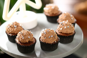 Cupcakes de chocolate decorados com estrelas prateadas, uma doce e encantadora adição à mesa de doces da festa de aniversário infantil.