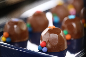 Deliciosos bombons de chocolate decorados com bolinhas coloridas, trazendo alegria e encanto à mesa de doces de uma divertida festa infantil.