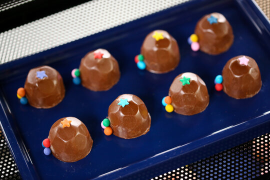 Deliciosos bombons de chocolate decorados com bolinhas coloridas, trazendo alegria e encanto &agrave; mesa de doces de uma divertida festa infantil.