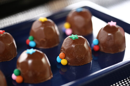 Deliciosos bombons de chocolate decorados com bolinhas coloridas, trazendo alegria e encanto &agrave; mesa de doces de uma divertida festa infantil.