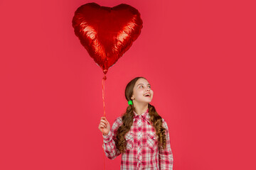 cheerful girl hold love heart balloon on red background