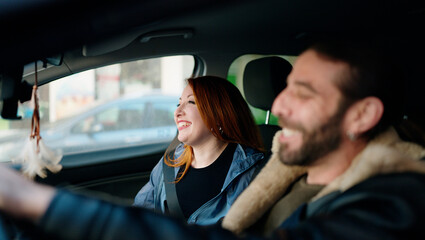 Man and woman couple smiling confident driving car at street