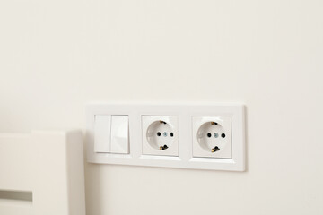 White light switch with sockets on a white wall