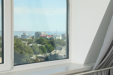 Fototapeta na wymiar A window with a view of the city in the apartment