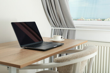 A cup of coffee and a laptop on the table