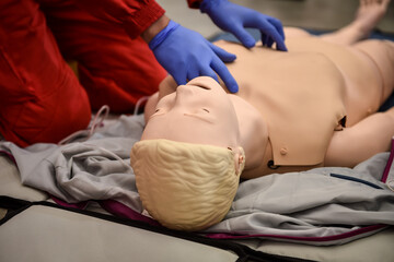 Paramedics simulate emergency intervention on medical training manikin - 622031044