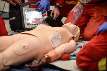 Paramedics simulate emergency intervention on medical training manikin - 622031095