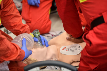 Paramedics simulate emergency intervention on medical training manikin - 622031096