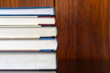 Stack of books in front of wood paneling