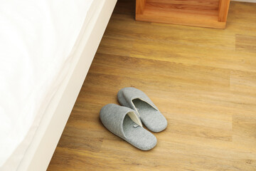 Gray slippers on the floor by the bed