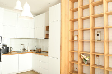 Modern kitchen in white colors and wooden shelves