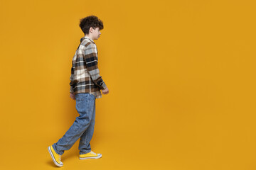 Naklejka premium A teenager in a shirt on a yellow background, place for text