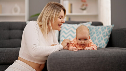 Mother and daughter sitting together smiling at home