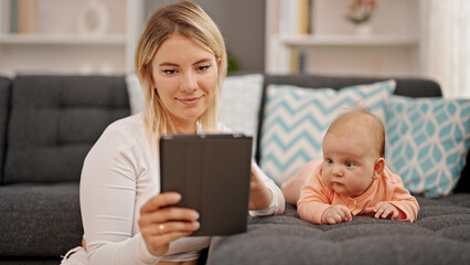 Mother and daughter using touchpad sitting together at home