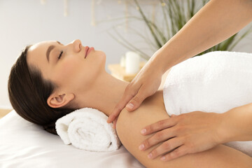 Fototapeta na wymiar Young attractive woman in spa enjoying massage