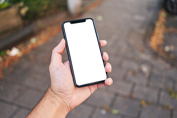Man holding smartphone showing white blank screen at street