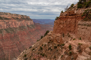 Panoramic aerial view from South Kaibab hiking trail at South Rim of Grand Canyon National Park, Arizona, USA. Colorado River weaving through valleys and rugged terrain. Ponds on track after rain