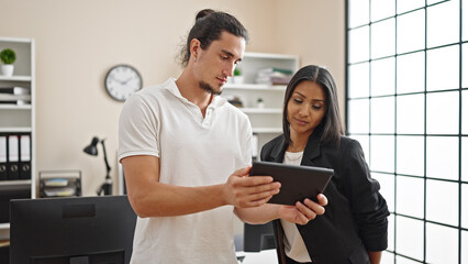 Fototapeta premium Man and woman business workers using touchpad working at office