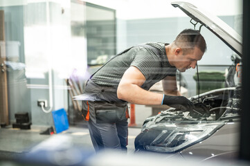 the mechanic fixes the car taking the tools from the table