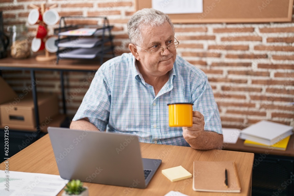 Canvas Prints Middle age grey-haired man business worker using laptop drinking coffee at office