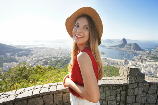 Portrait of smiling relaxed traveler woman on viewpoint with Guanabara Bay in Rio de Janeiro, Brazil