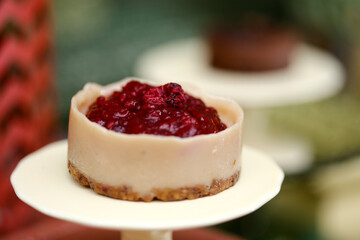 Delicioso cheesecake coberto com frutas vermelhas, servido em uma elegante louça bege, em um evento requintado.