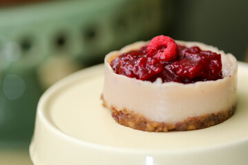 Delicioso cheesecake coberto com frutas vermelhas, servido em uma elegante louça bege, em um evento requintado.