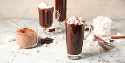 Glass cups of tasty hot chocolate with marshmallows on light table