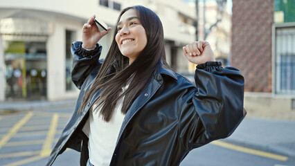 Young beautiful hispanic woman smiling confident using smartphone dancing at street