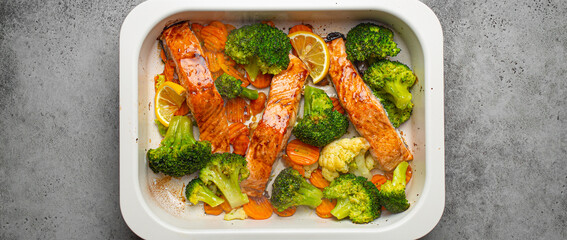 Top view of healthy baked fish salmon steaks, broccoli, cauliflower, carrot in casserole dish....