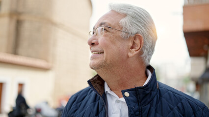 Middle age man with grey hair smiling confident looking up at street