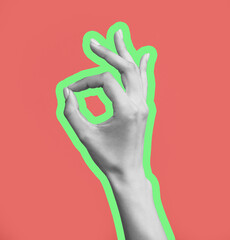 Female hand showing OK gesture on pink background
