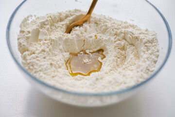 White flour with oil in glass bowl, ready to cook dough. Cooking homemade meal.