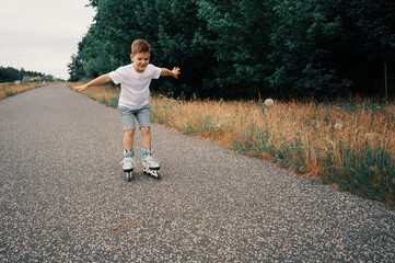 Smiling boy 7 years old rides on roller skates