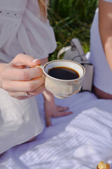 woman holding cup of coffee on the picnic