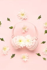 Composition with modern headphones and beautiful chrysanthemum flowers on pink background