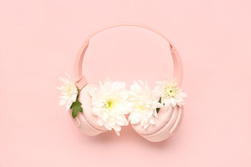 Composition with modern headphones and beautiful chrysanthemum flowers on pink background