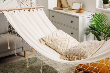 Fototapeta na wymiar Cozy hammock with cushions in interior of living room